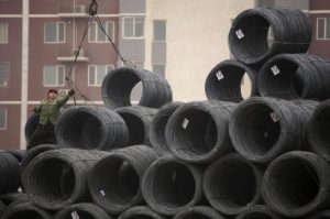 A labourer works on coils of steel wire at a steel wholesale market in Beijing